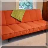F27. Crate & Barrel CB2 orange futon. 33”h x 80”w x 40”d 